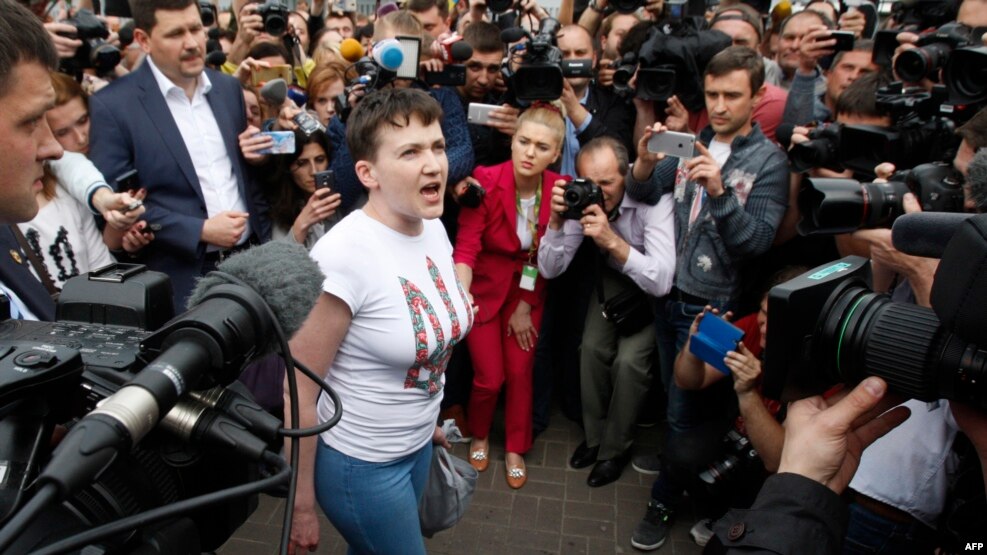 Nadija Savchenko duke folur me gazetarë pasi arriti në aeroportin e Kievit