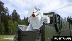 A Russian military truck with a laser weapon mounted on it is shown at an undisclosed location in Russia. 