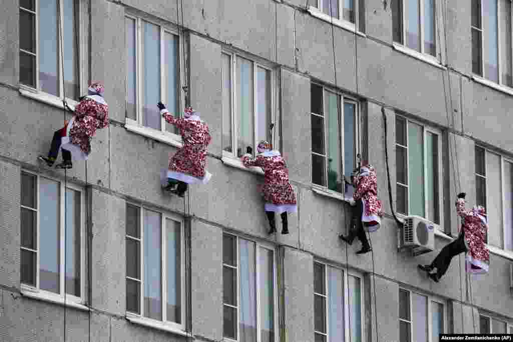 Russian emergency rescue workers dressed as Ded Moroz (Santa Claus or Father Frost ) scale the wall of a children's hospital in Moscow. (AP/Alexander Zemlianichenko)