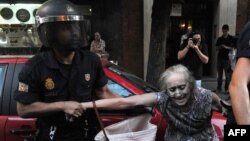 Полиция шеруге шыққан әйелді тұтқындап барады. Испания, 13 шілде 2012 жыл. (Көрнекі сурет).