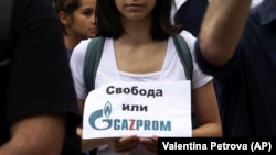 Protestatară cu un afiș pe care scrie în bulgară „Libertate sau Gazprom” în timpul unui protest în centrul Sofiei, în fața clădirii Președinției bulgare. 10 august 2022