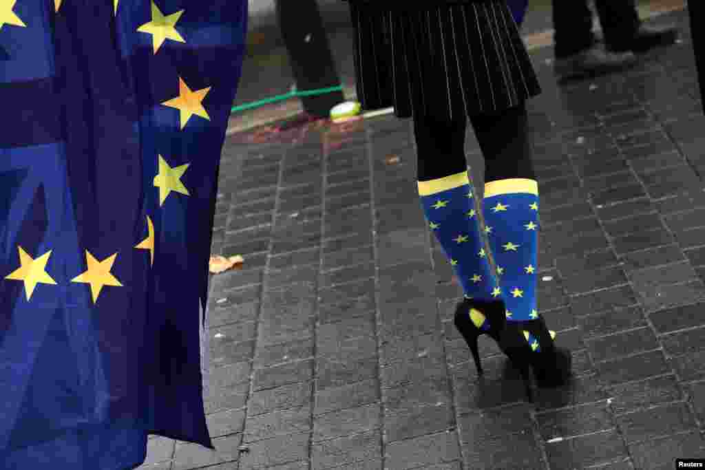 ВЕЛИКА БРИТАНИЈА - Демонстрантка со чорапи во боите на ЕУ протестира во Лондон против планот на Велика Британија за напуштање на Европската Унија. Британските пратеници дополнително ги поткопаа плановите на премиерката Тереза Меј за Брегзитот со тоа што на парламентот му дадоа конечен збор за каква и да е спогодба што владата ќе ја постигне со Европската унија. Со тоа на парламентот му се дава право на вето на Брегзитот.