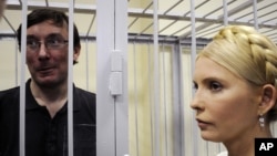 Former Ukrainian Interior Minister Yuriy Lutsenko (left) in a defendant's cage with former Prime Minister Yulia Tymoshenko in a courtroom in Kyiv in May 2011.