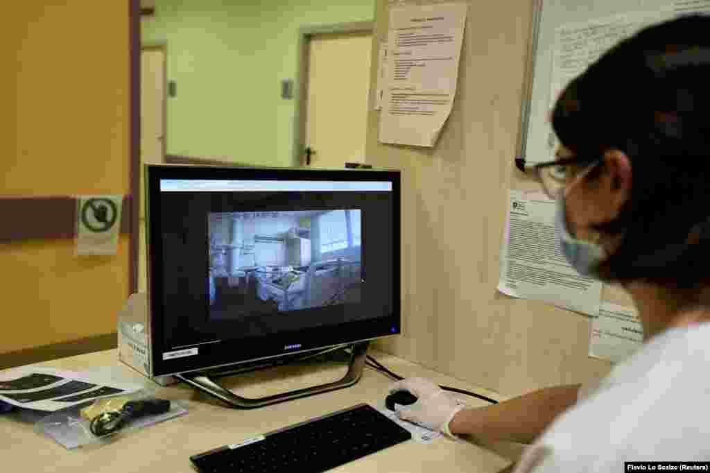 A health worker looks at the screen showing images taken by a robot helping medical teams treat patients suffering from the coronavirus disease (COVID-19), in the Circolo hospital, in Varese, Italy, April 1, 2020.