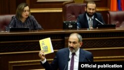 Armenia -- Prime Minister Nikol Pashinian holds a booklet listing his government's achievements during a parliament session in Yerevan, June 20, 2019.