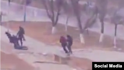 Люди на площади в Жанаозене убегают от стреляющих в них полицейских. Стоп-кадр видео очевидца