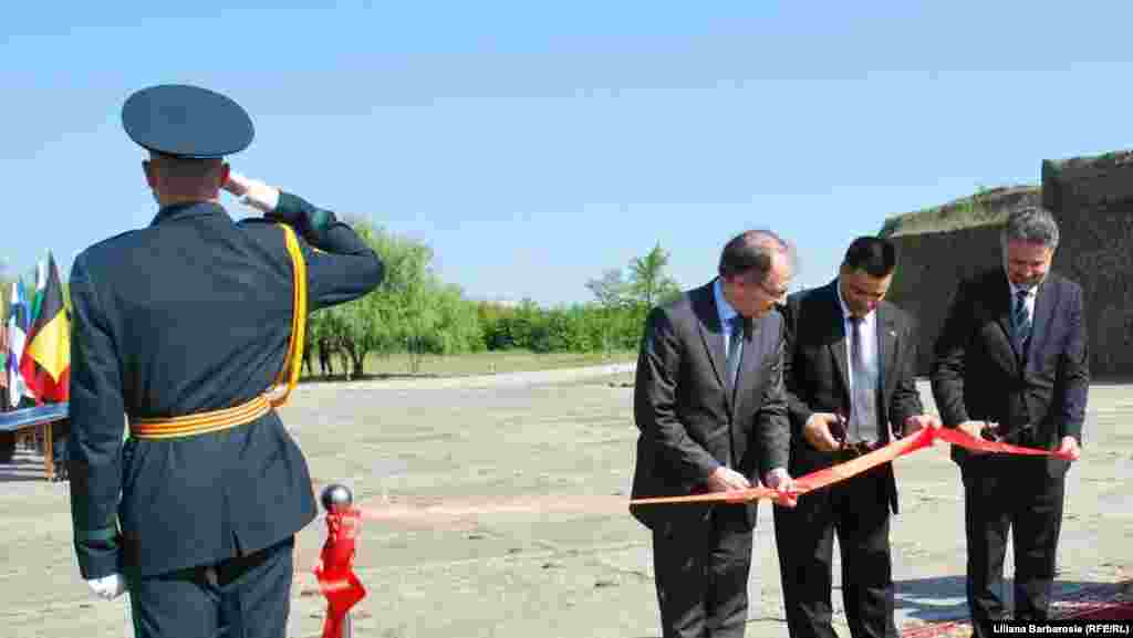 NATO Assistant Secretary-General Gabor Iklody (left) cuts a ribbon at the clearance site with Moldovan Defense Minister Vitalie Marina (center) and Romanian Ambassador Marius Lazurca.