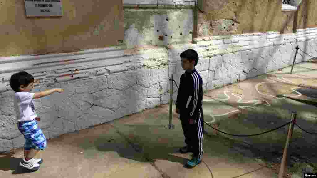 Children play near the spot where the late Romania dictator Nicolae Ceausescu and his wife Elena were executed on Christmas Day in 1989 at a former military barracks in Targoviste. (Reuters/Radu Sigheti)