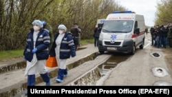 Medical workers are seen during the exchange of prisoners of war between Ukraine and the separatists near the Mayorsk crossing point in the Donetsk region on April 16.