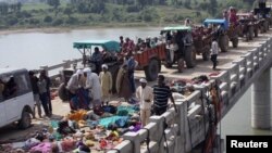 People walk past bodies of some of those killed in a stampede on a bridge near the Ratangarh temple in the Datia district in the central Indian state of Madhya Pradesh on October 13 after rumors of a bridge collapse set off panic.