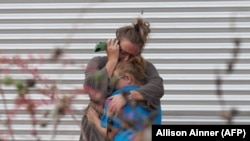 Жена плаче и прегрнува млада девојка покрај граѓанскиот центар Вили де Леон, каде што се дава поддршка по нападот во Увалде, Тексас, на 24 мај 2022 година