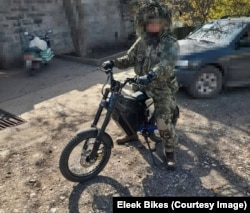 Un militar ucrainean pe o bicicletă electrică.