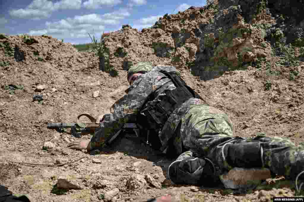 A Ukrainian serviceman takes cover during shelling.