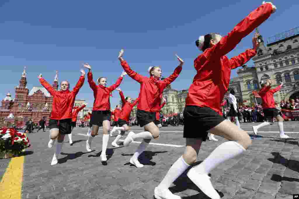 Момичета с червени кърпички танцуват на Червения площад. Церемонията в Москва е организирана за отбелязване на 100-годишнината от основаването на организацията на младите пионери.