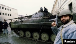 Combatanți ceceni, în jurul unor blindate rusești distruse în bătălia de la Groznîi din ianuarie 1995.