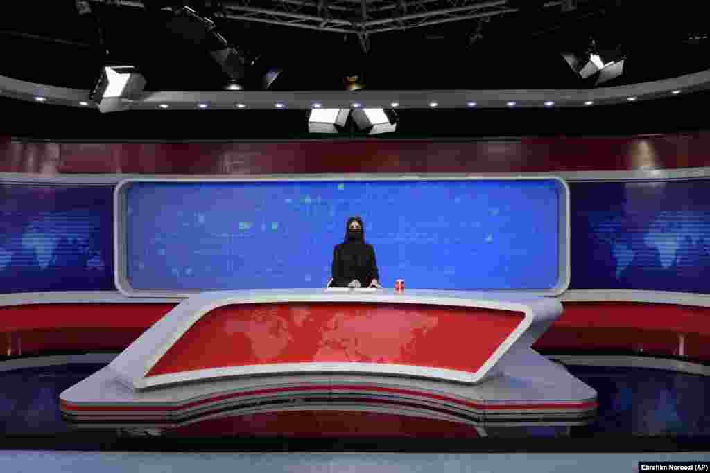Водителката на ТОЛО, Катерех Ахмади носи марама на лицето додека ги чита вестите во Кабул, Авганистан, на 22 мај 2022 година. Талибанците продолжуваат да го применуваат своето толкување на исламскиот закон, барајќи од сите жени водителки на ТВ вести да ги покриваат лицата. (AP Photo/Ebrahim Noroozi)