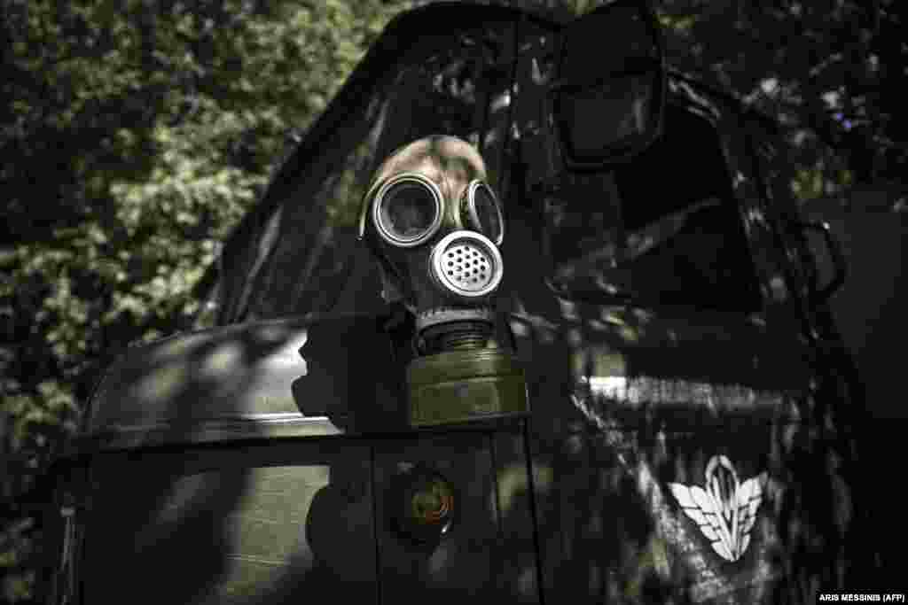 A gas mask sits atop a military vehicle at a checkpoint manned by Ukrainian servicemen.