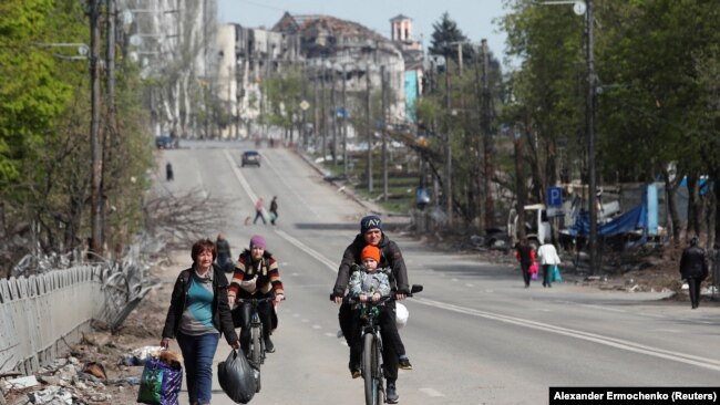 Banorët e Mariupolit udhëtojnë përgjatë një rruge, prill 2022.