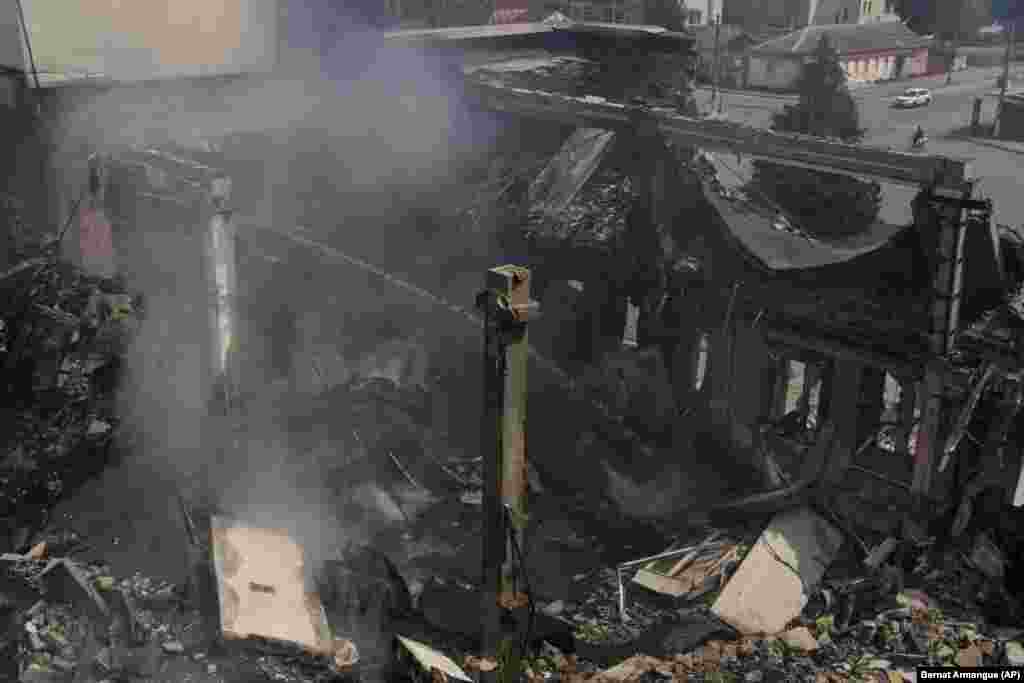 A Ukrainian firefighter works inside a destroyed cultural center in Derhachi in eastern Ukraine.