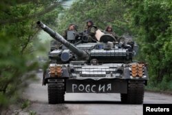 Российские военнослужащие едут на танке в Донецкой области, 22 мая 2022 года