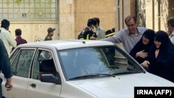 Dy gra duke qarë afër makinës së kolonelit të vrarë, Sayad Khodai në Teheran.