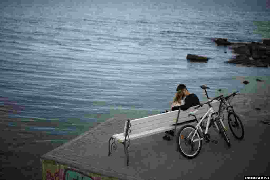 A couple sit on a bench.