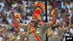 Офицеры Пограничных сил Индии проводят традиционную церемонию закрытия ворот на пограничном переходе в Вагахе на границе с Пакистаном. Это отчасти театральное агрессивное представление давно стало одним из символов военного противостояния Индии и Пакистана. 14 августа 2025 года