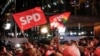 A német Szociáldemokrata Párt hívei ünnepelve fogadják az exit pollokat 2021. szeptember 26-án. A SPD párszázalékos többséggel nyerte a szövetségi választásokat