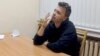 Raman Pratasevich smokes a cigarette while speaking in a video from a detention center in Minsk, broadcast by the state-controlled ONT channel on June 2. "I have noticed handcuff marks on his hands," his mother says. 