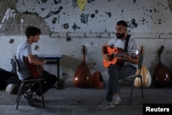 Youssef Jibrilnek ad Mohammad Abu Mahadi gitárórát augusztus 9-én a Gázai Főiskola repeszek lyuggatta falai között