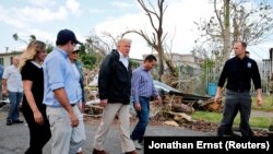 U.S. President Donald Trump walks past hurricane wreckage as he participates in a walking tour in Puerto Rico on October 3.