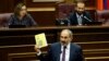 Armenia -- Prime Minister Nikol Pashinian holds a booklet listing his government's achievements during a parliament session in Yerevan, June 20, 2019.