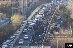 Власники крамниць і торговці йдуть мостом під час протесту проти економічної ситуації та кризового стану іранської валюти в Тегерані, 29 грудня 2025 року