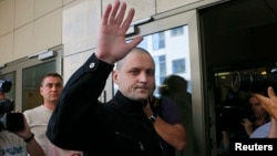 Sergei Udaltsov (center) gestures to supporters and reporters as he enters a court building in Moscow in July 2014.