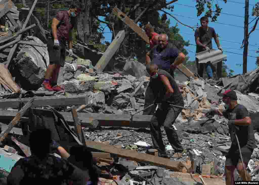 People clear debris at the Lyubotyn Vocational Railway Transport College near Kharkiv. At least three civilians were killed and seven were injured as Russian forces intensified their shelling of the Kharkiv region in the last 24 hours, according to&nbsp;regional Governor Oleh Synyehubov in a Telegram post on June 21.