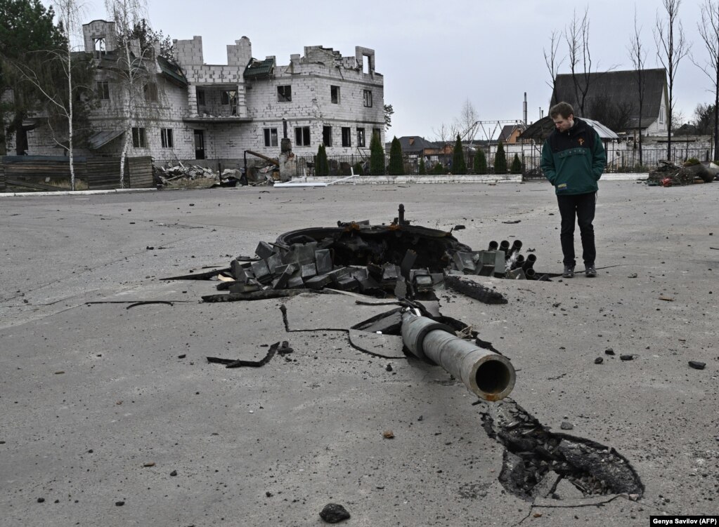 A man inspects the turret of a destroyed tank in Zalissya, a town northeast of Kyiv, on April 12.