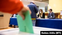 Egy nő leadja szavazatát a nyíregyházi gimnáziumban az országgyűlési választáson és gyermekvédelmi népszavazáson 2022. április 3-án