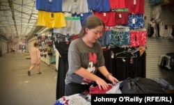 Zhenya Polyakova closes up shop in a market, slowly returning to normality after being struck by missiles.