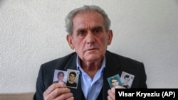 Haljilj Hasani, iz okoline Zubinog Potoka, pokazuje novinarima AP-a u maju 2020., fotografije svoja četiri sina kidnapovana juna 1999. godine. Od tada im se gubi svaki trag. 