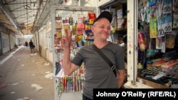 Lemar Osmanov gives the peace sign at his hardware shop which was narrowly missed by Russian missiles.