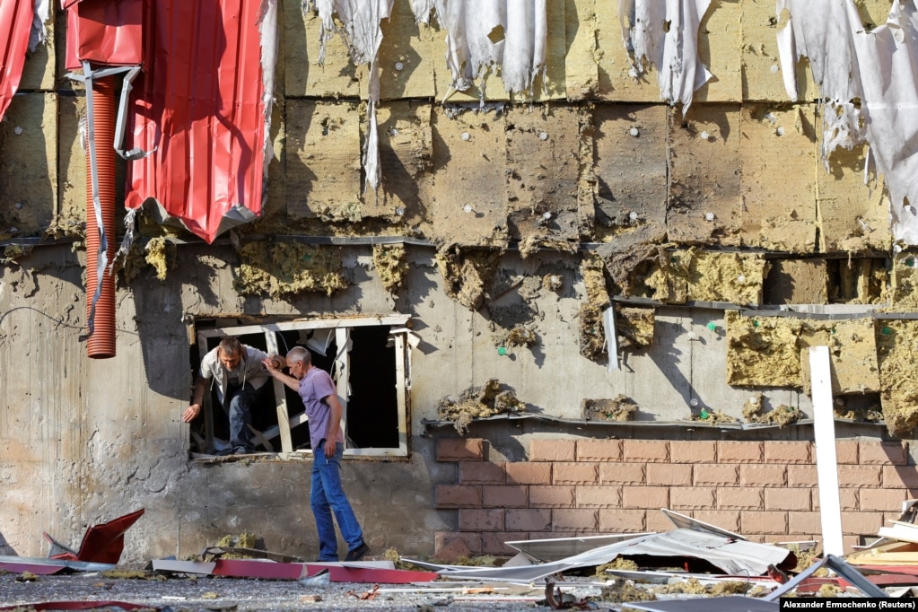 Një burrë duke dalë nga dritarja e një ndërtese banimi të dëmtuar pas bombardimeve në Donjeck, Ukrainë, më 20 qershor.