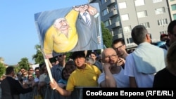 Хора държат плакат с образа на Бойко Борисов и Слави Трифонов по време на демонстрацията в подкрепа на правителството на Кирил Петков.
