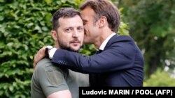 Volodimir Zelenski și Emmanuel Macron se îmbrățișează după ce au susținut o conferință de presă la Palatul Mariinski din Kiev, pe 16 iunie 2022. 