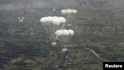 Russian airborne combat vehicles descend on parachutes during joint exercises by the armed forces of Russia and Belarus in Kaliningrad, Russia, in September 2021.