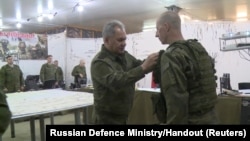 Russian Defense Minister Sergei Shoigu awards a soldier during an inspection of Russian troops reportedly engaged in the Ukraine invasion at an unknown location and date.