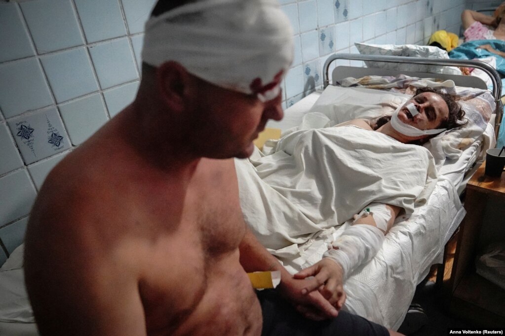 Një çift i plagosur në një qendër tregtare në Kremençuk, që&nbsp;u godit nga një raketë ruse, shihen kapur për dore teksa po tratohen në një spital. Të paktën 18 persona u vranë në këtë sulm.