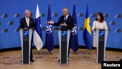 Министры иностранных дел Финляндии и Швеции и генеральный секретарь НАТО после подписания протоколов о присоединении двух стран к альянсу
