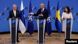 NATO Secretary-General Jens Stoltenberg (center), Finnish Foreign Minister Pekka Haavisto (left) and Swedish Foreign Minister Ann Linde hold a joint press conference after signing the countries' accession protocols at NATO headquarters in Brussels on July 5.