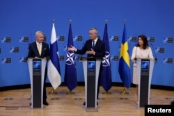 Ministrul de externe al Suediei, Ann Linde (dreapta), și ministrul de externe al Finlandei, Pekka Haavisto (stânga), participă la o conferință de presă cu secretarul general al NATO, Jens Stoltenberg, după semnarea protocoalelor de aderare a țărilor lor la sediul alianței din Bruxelles, Belgia, 5 iulie 2022.