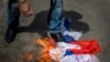 Демонстрант сжигает российский флаг в Вильнюсе
